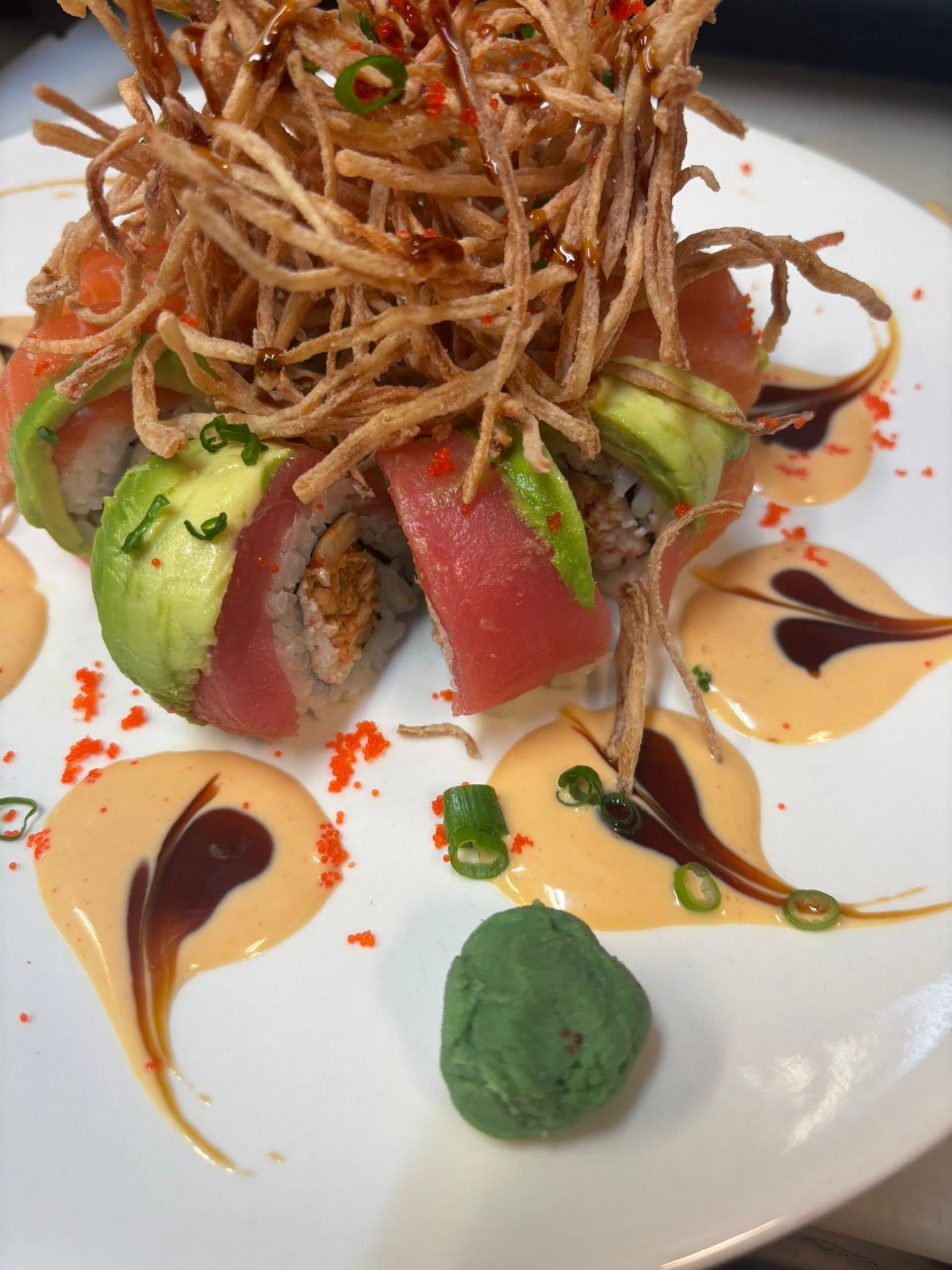 Specialty tuna roll topped with crispy noodles, avocado, and spicy mayo