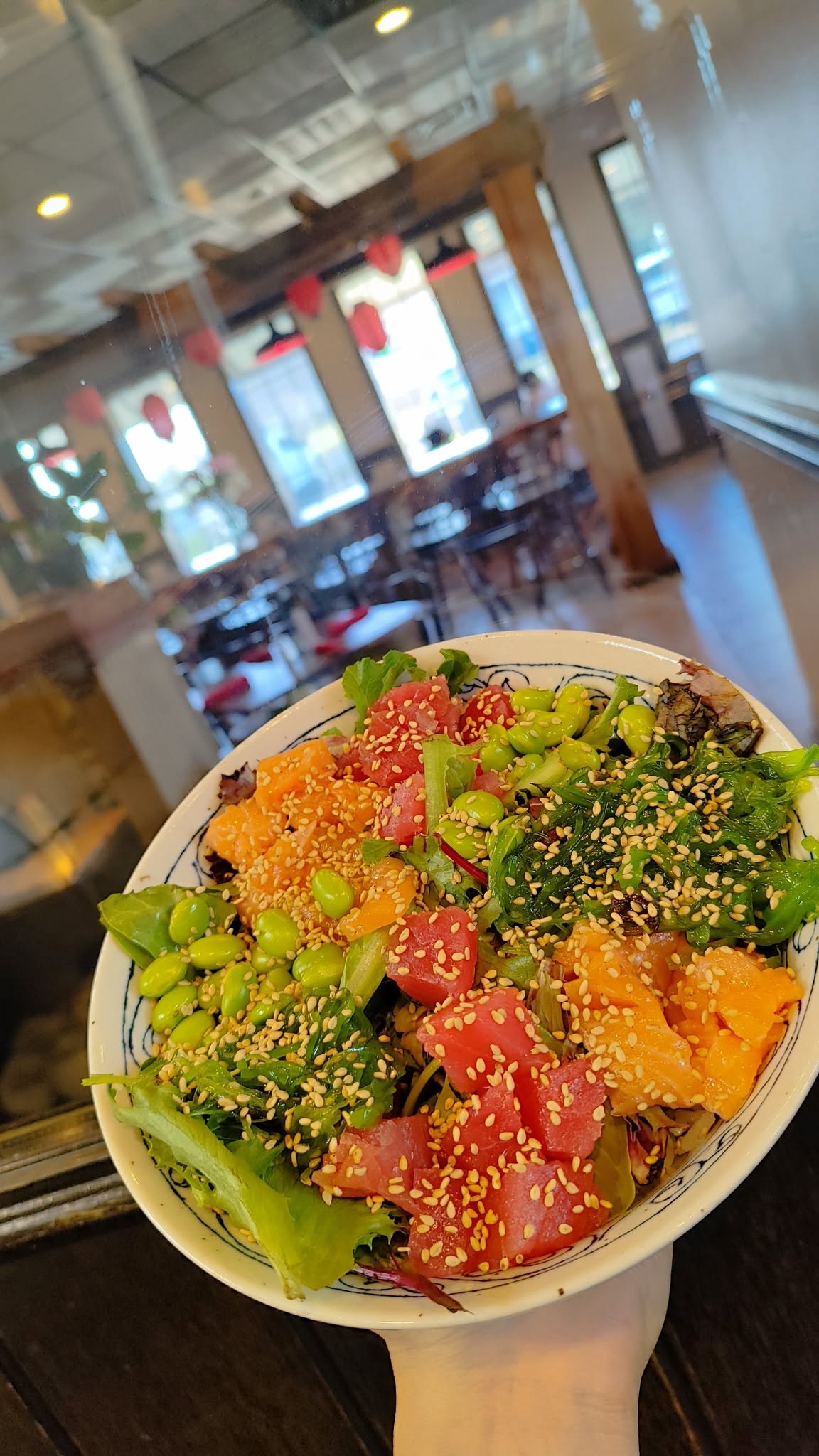 Poke bowl with tuna, salmon, edamame, and sesame seeds