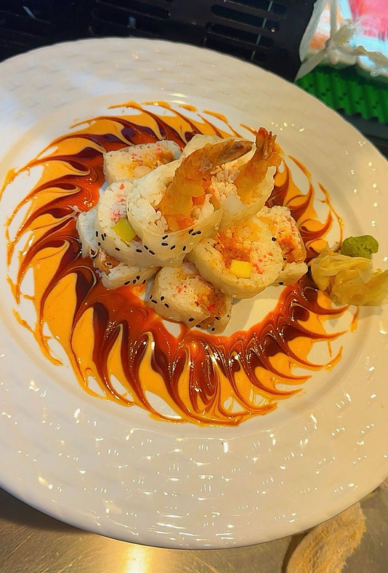 Shrimp sushi roll on white plate with swirled sauce