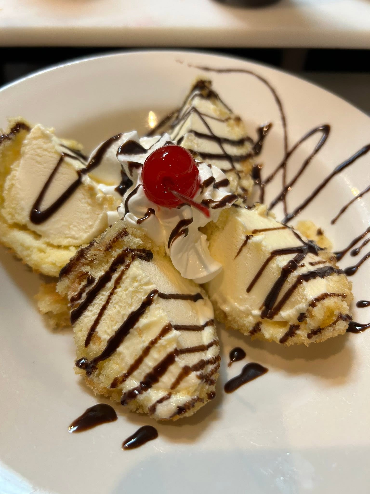 Fried ice cream with chocolate drizzle and cherry