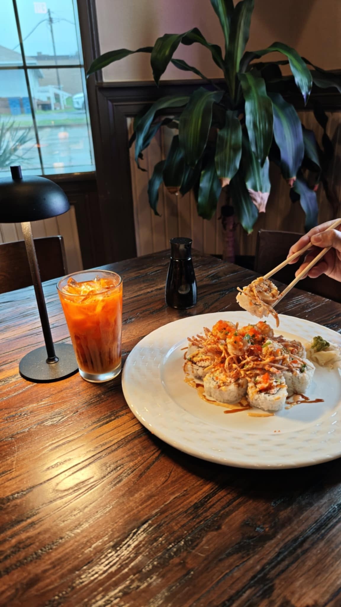 Sushi roll and Thai iced tea at a table inside Mario's Asian Grill