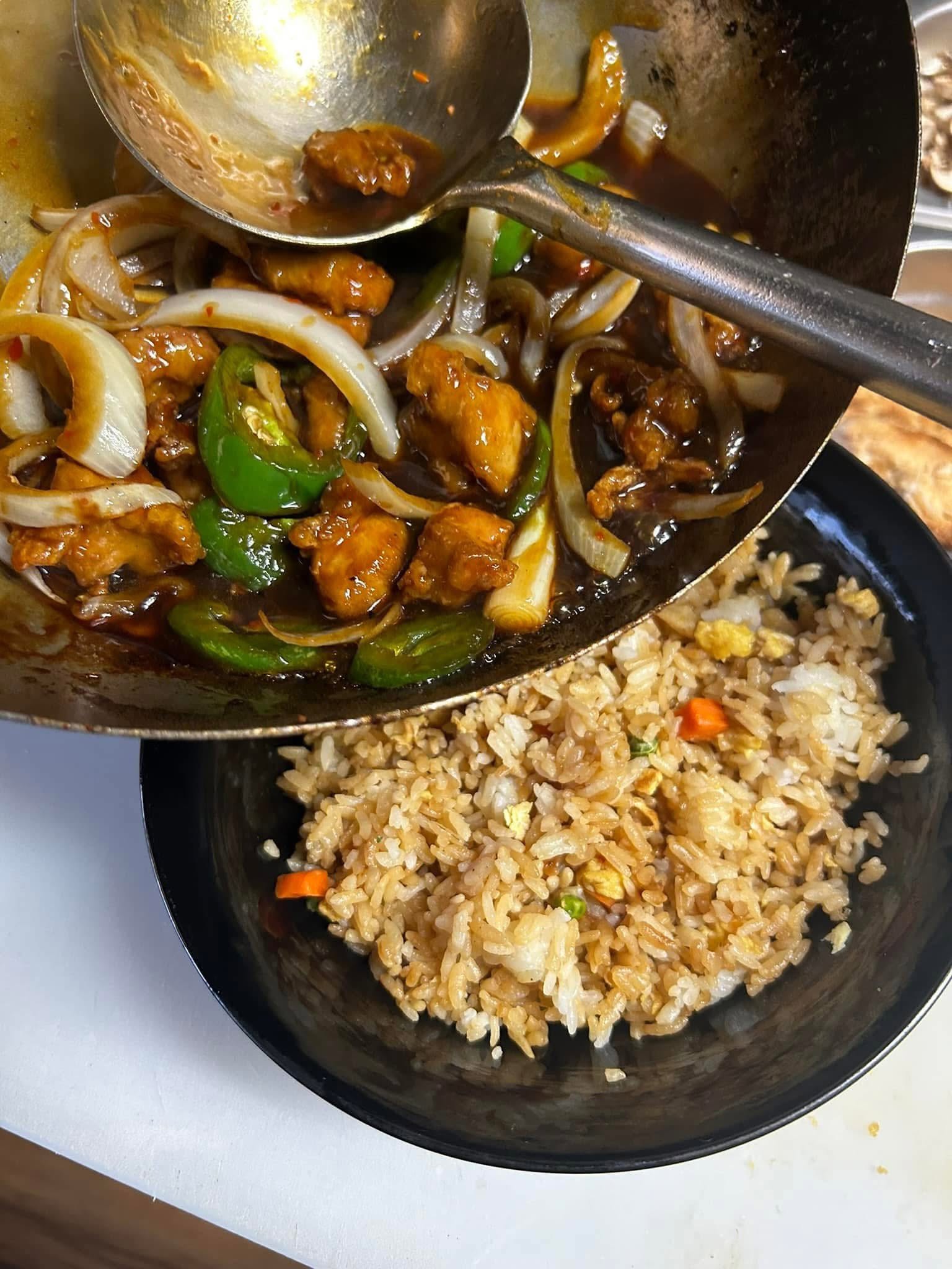 Wok-tossed chicken with peppers and onions over fried rice